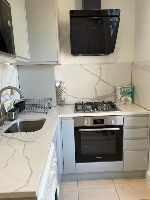 a small kitchen with a stove and a sink at Green lanes N8, Studio flat! in London