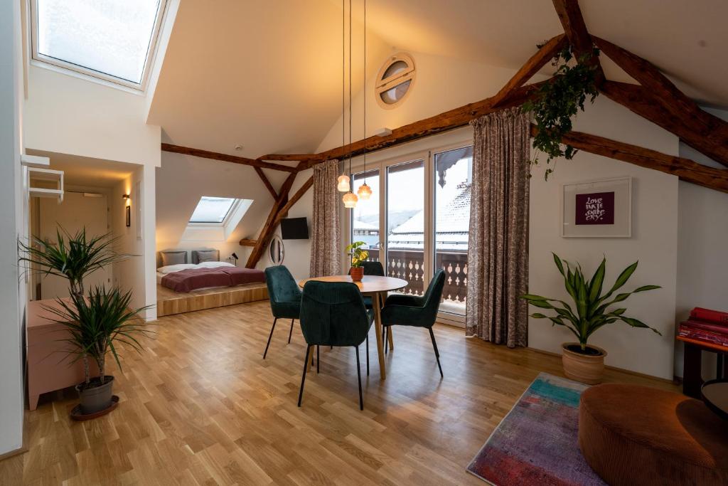 ein Wohnzimmer mit einem Tisch und Stühlen sowie ein Schlafzimmer in der Unterkunft NOAS Home in Innsbruck