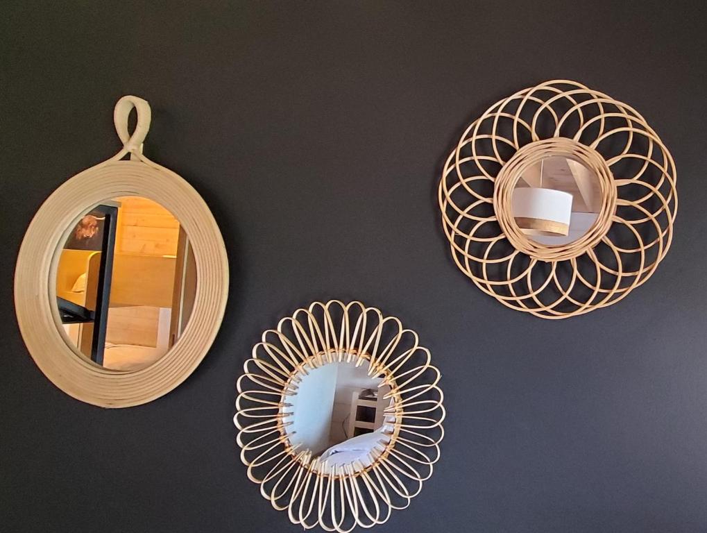 three mirrors are hanging on a wall at Au Charm'Han in Han-sur-Lesse