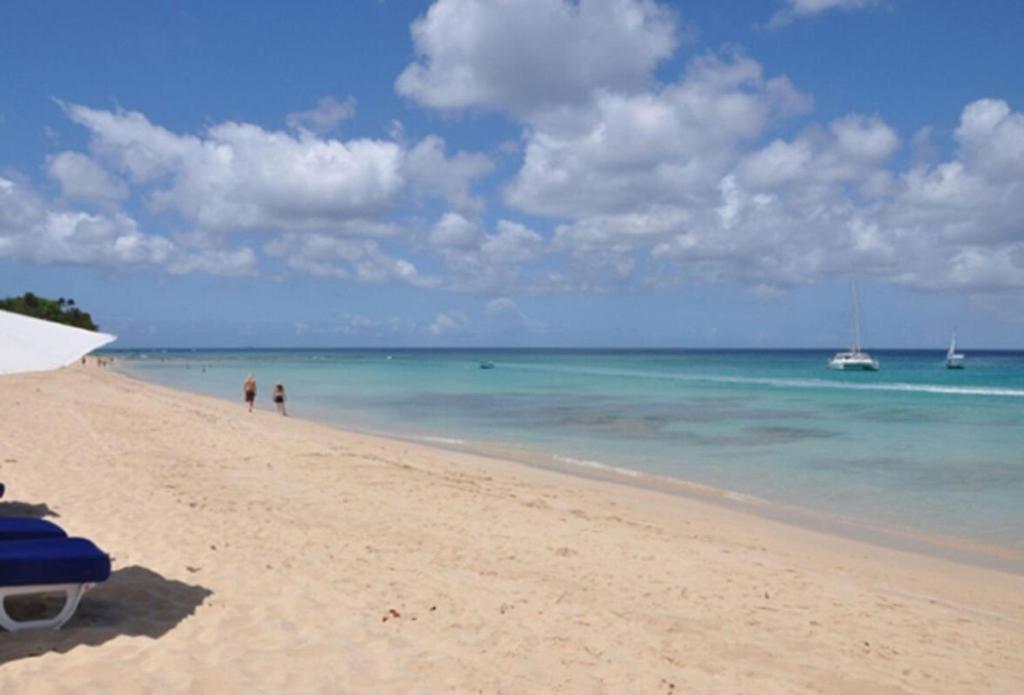 een strand met mensen en boten in het water bij Bora Bora by Blue Sky Luxury in Saint James