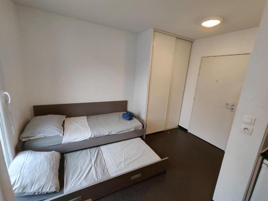 a small room with two beds and a door at Le Stratège in Marseille