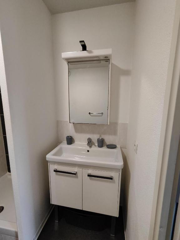 a bathroom with a white sink and a mirror at Le Stratège in Marseille