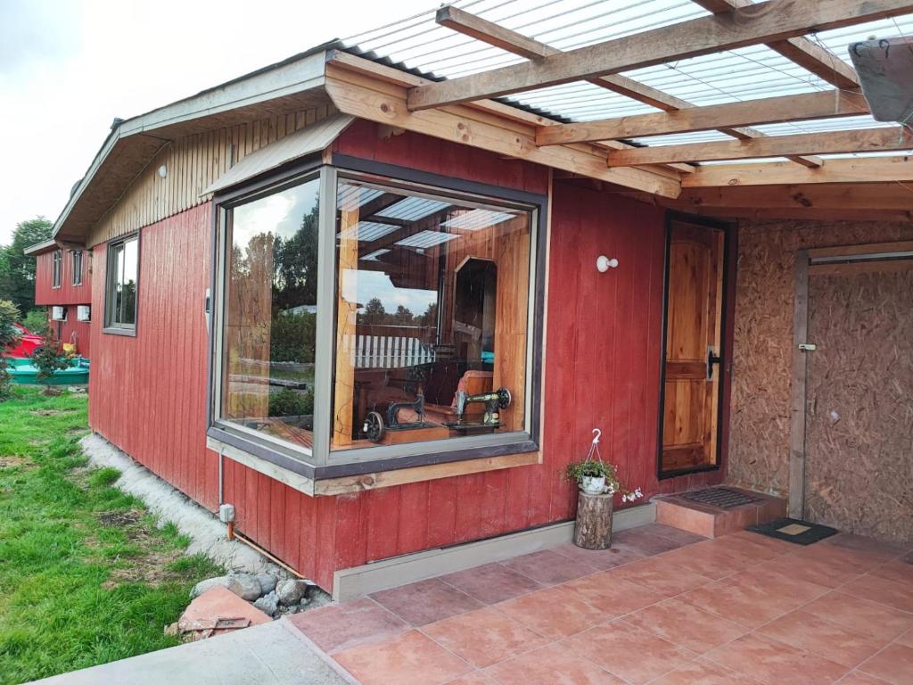 czerwony dom z dachem słonecznym na patio w obiekcie Cabañas Rayen Karu w mieście Puerto Montt