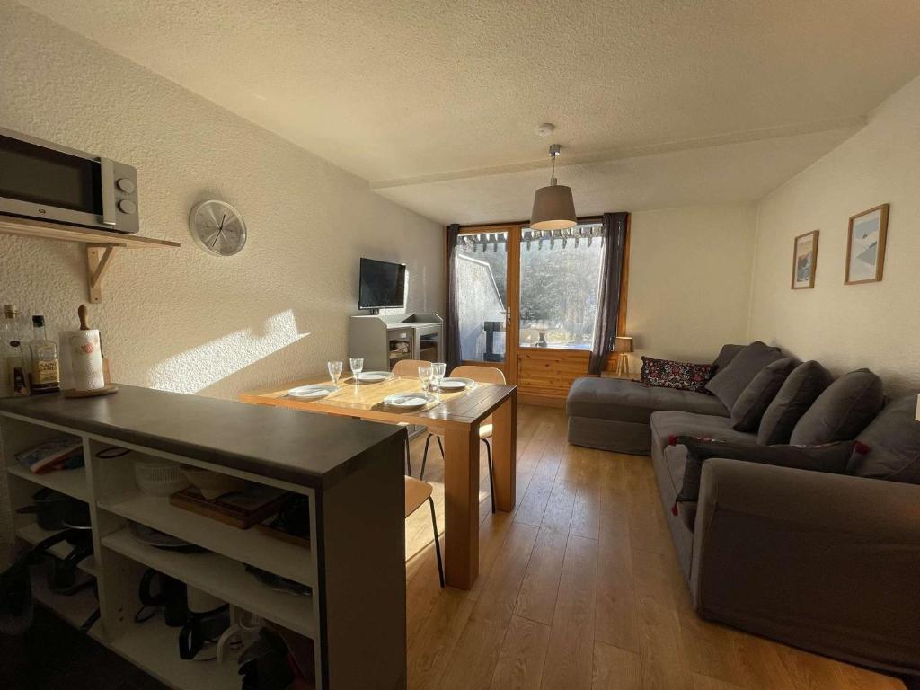 una sala de estar con un sofá y una mesa en Charmant studio rénové à Chantemerle avec jardin, parking et WIFI, idéal pour 4 personnes - FR-1-330E-111, en Champcella