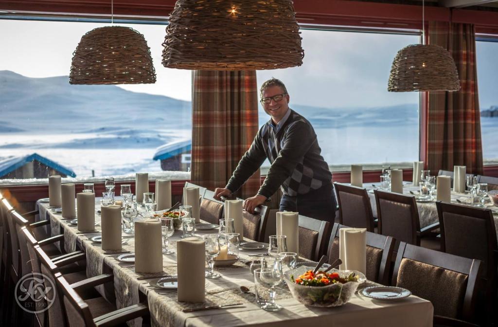 Um homem de pé numa mesa num restaurante em Bergsjøstølen Fjellstue em Bergsjostolen