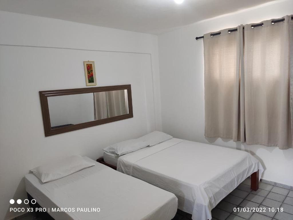 2 camas en una habitación pequeña con espejo en Pousada Temporada Atlântica, en Fortaleza