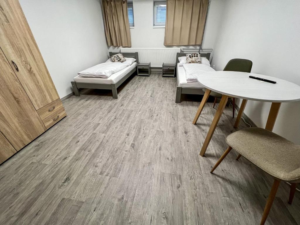 um quarto com uma mesa e uma cama e uma mesa e cadeiras em Hostel H18 em Bardejov