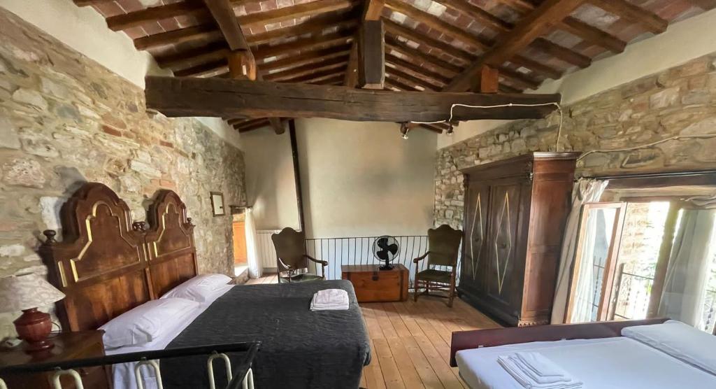 1 dormitorio con cama y pared de piedra en Il Fiore di Montieri, en Montieri