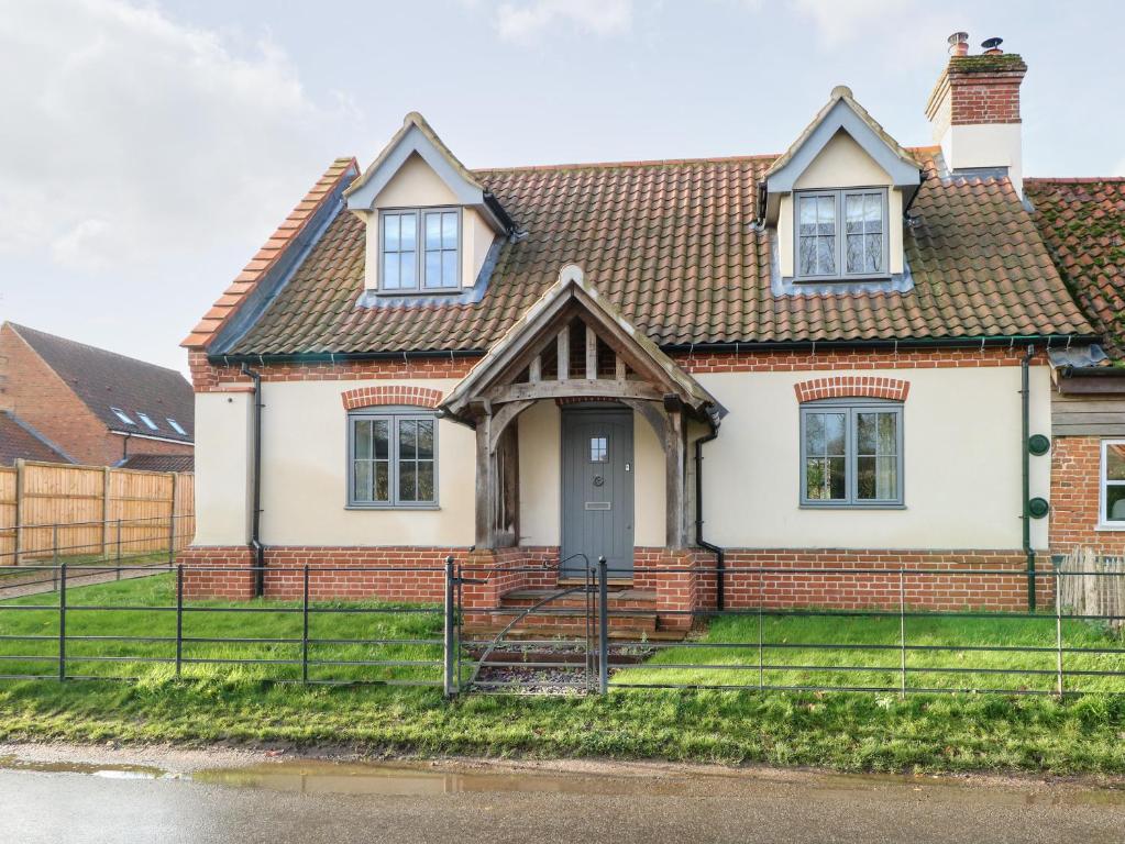 a brick house with a brown roof at Hillside Cottage in Beeston