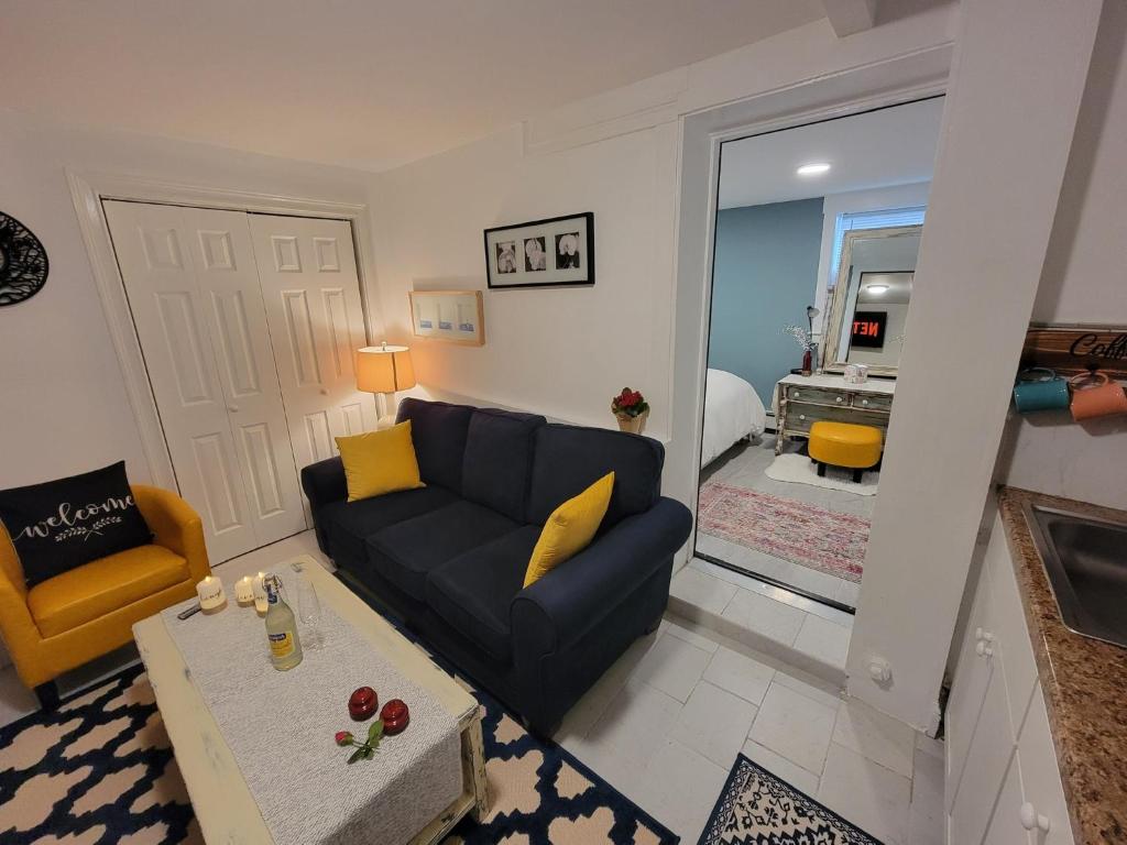 a living room with a blue couch and a yellow chair at Comfy and Chic Boston Apartment! in Boston