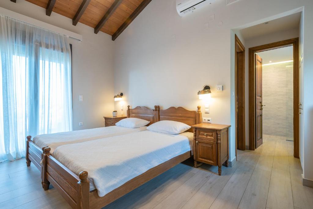 a bedroom with a large bed and a bathroom at Amigdalies in Myrina