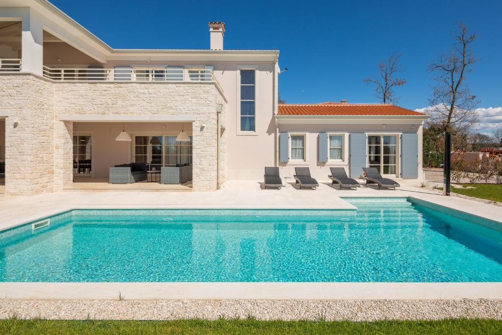 a swimming pool in front of a house at Villa Harmony by ILC (Istria Luxury Collection) in Brtonigla