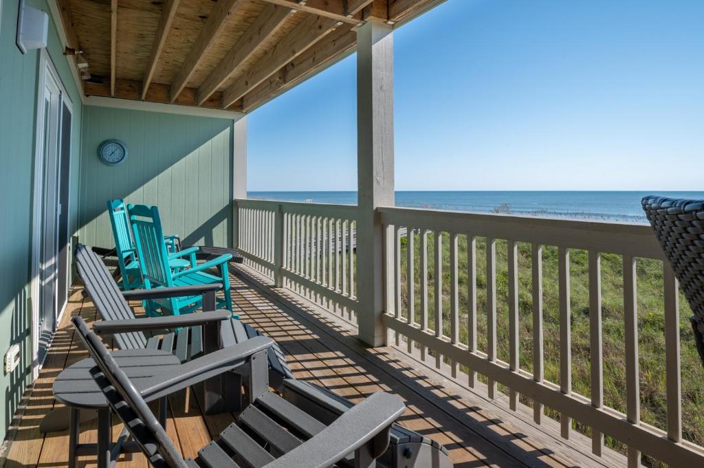 a porch with rocking chairs and the beach at Sands IV 2-G in Carolina Beach
