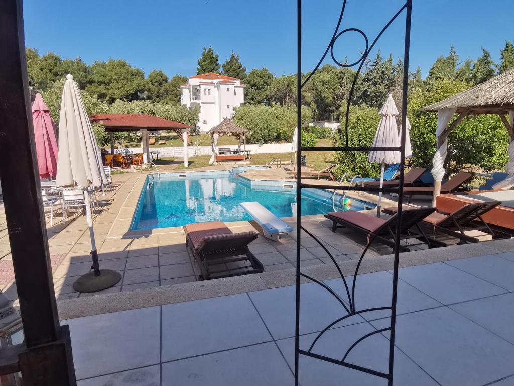 a swimming pool with lounge chairs and umbrellas at Villa Askamnia and Suites in Nikiti