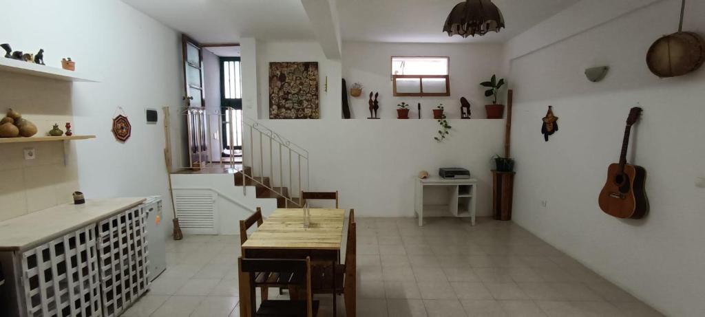 a living room with a table and a guitar on the wall at Kaza Jindung in Mindelo