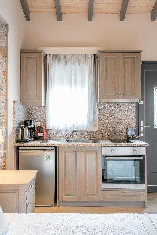 a kitchen with wooden cabinets and a sink and a window at Amigdalies in Myrina