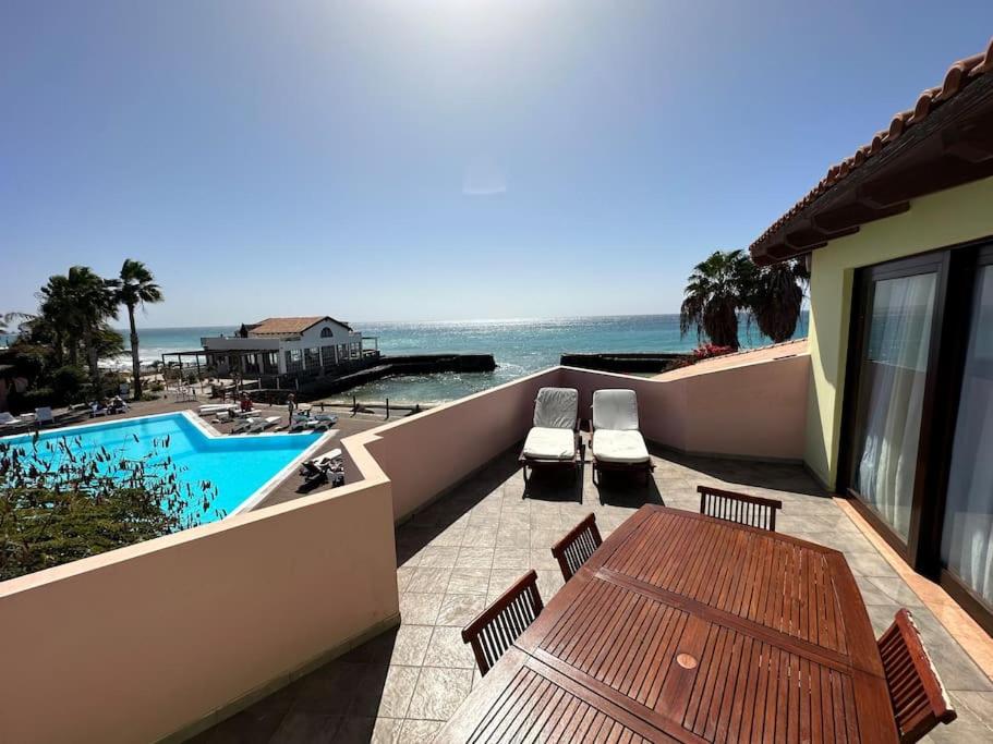 une terrasse avec une table et des chaises et l'océan dans l'établissement Porto Antigo 1 - Beach apartments, à Santa Maria