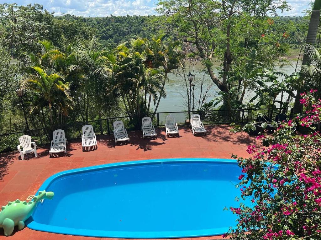 a swimming pool with chairs and a view of the water at Costa del Sol Iguazú in Puerto Iguazú