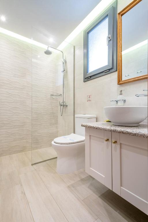 a bathroom with a sink toilet and a glass shower at Amigdalies in Myrina