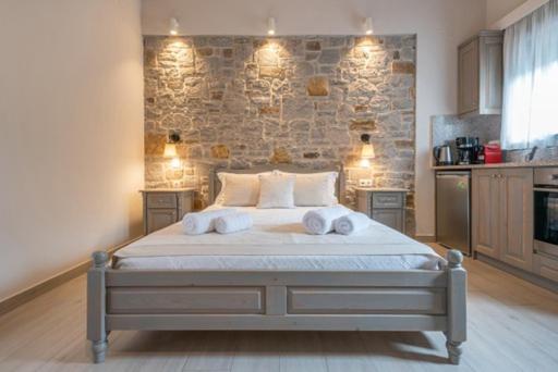 a bedroom with a large bed with two towels on it at Amigdalies in Myrina