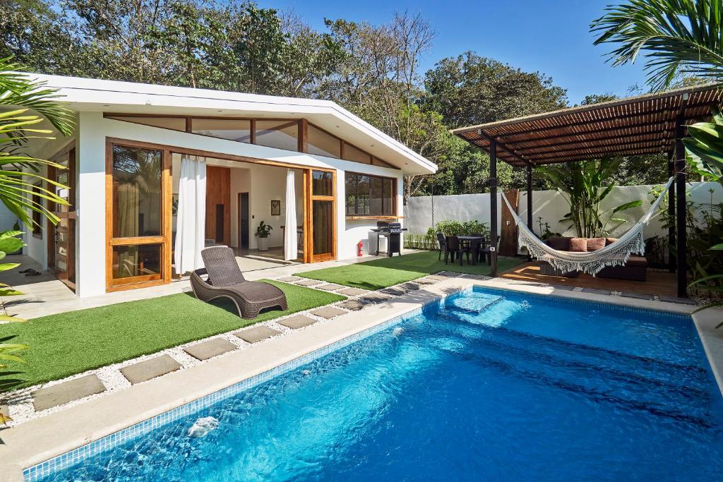 a pool with a hammock and a house at Villa Akari - Brand new 2bedrooms Villa with Pool in Carmen