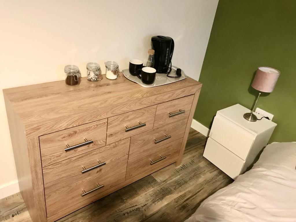 a wooden dresser in a bedroom with a bed at 27 William Jessop Way Bristol BS13 0RL in Whitchurch