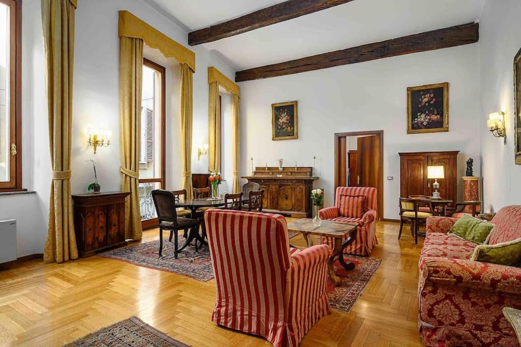 uma sala de estar com cadeiras vermelhas e uma mesa em Piazza DUOMO - Antico Appartamento dell'800 em Milão