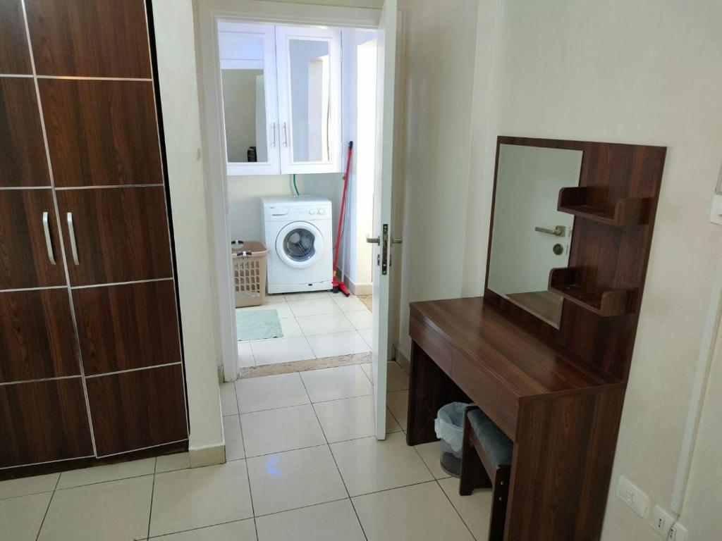 a bathroom with a mirror and a washing machine at Nice tow bedrooms by snake pool in talapay in Aqaba