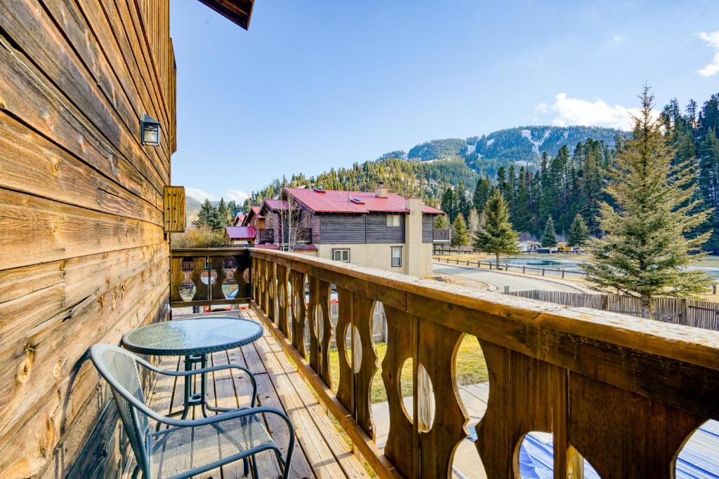 balcón con mesa y sillas sobre una valla de madera en Mountain Rider - Unit A en Red River