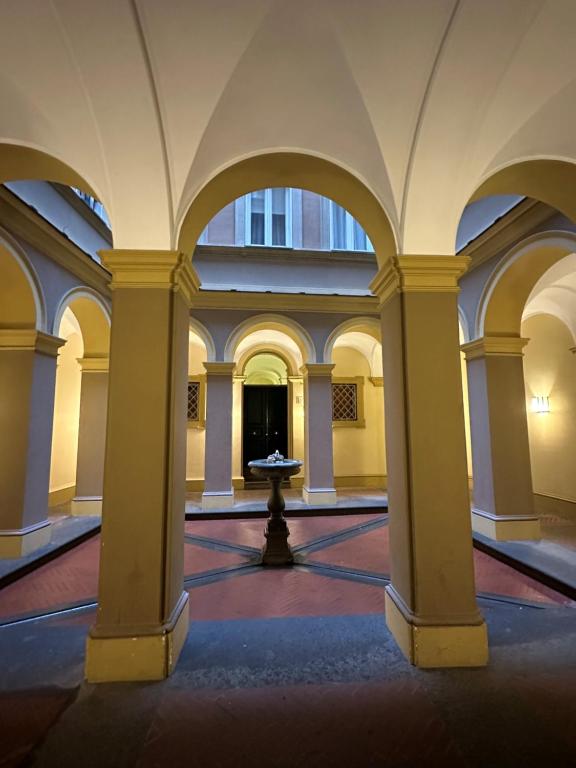 an empty room with columns and a fountain in the middle at Gio Luxury Home in Rome