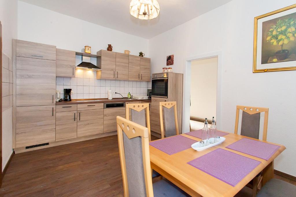 a kitchen with a wooden table and a dining room at Apartment Zoey in Auerbach