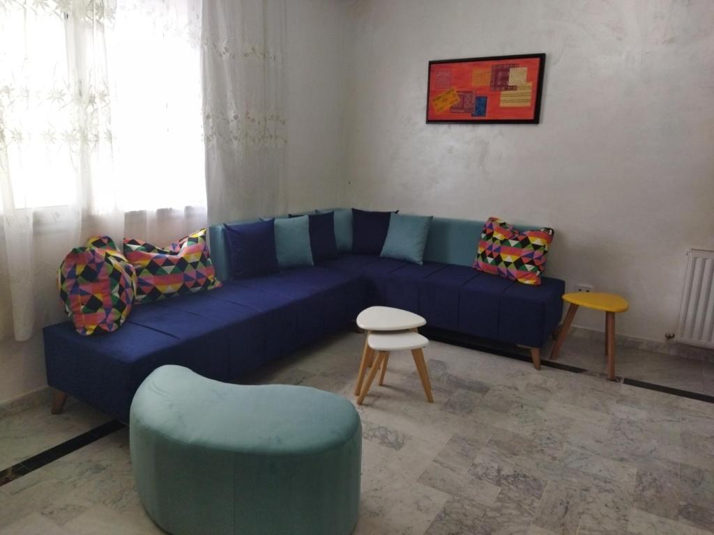 a living room with a blue couch and chairs at cozy appartement D6 in Hammamet