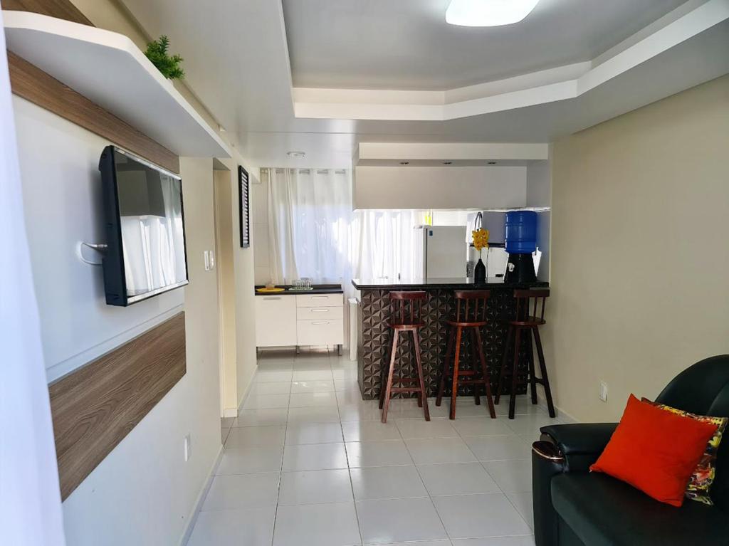 a living room with a couch and a kitchen at Apartamento Na Praia do Guaibim - Valença-Ba in Guaibim