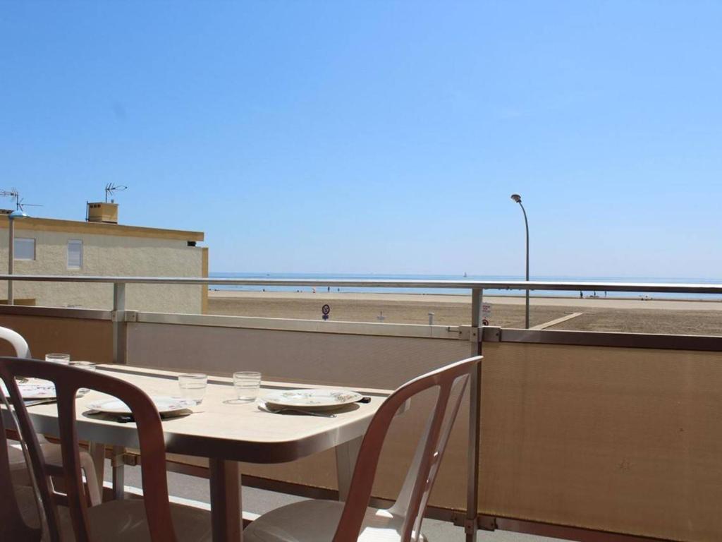 uma mesa e cadeiras numa varanda com vista para a praia em Appartement Port-la-Nouvelle, 2 pièces, 4 personnes - FR-1-229C-20 em Port-la-Nouvelle