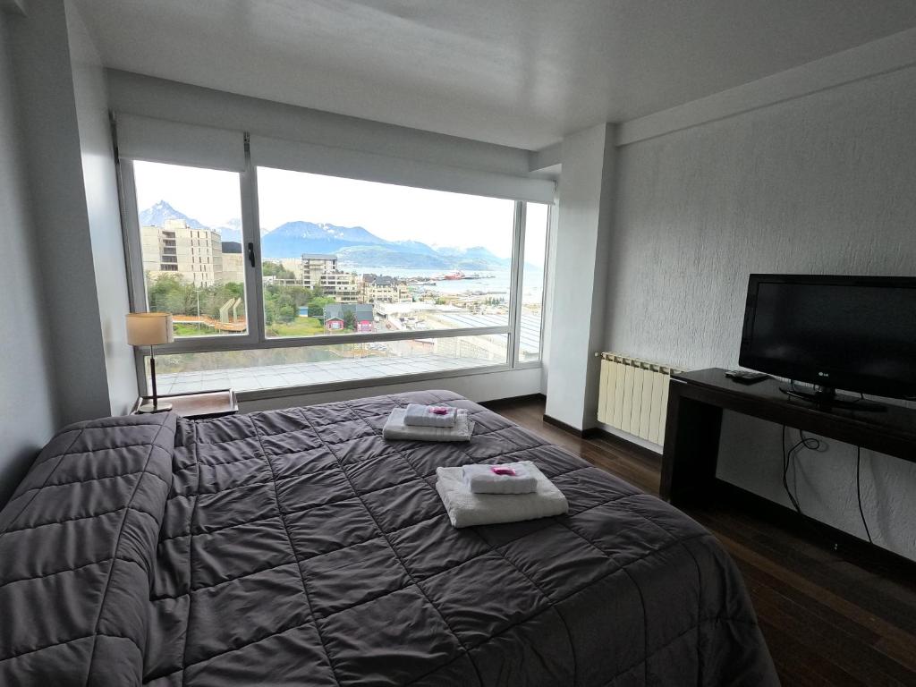 a bedroom with a bed and a large window at El Descanso - Ushuaia in Ushuaia
