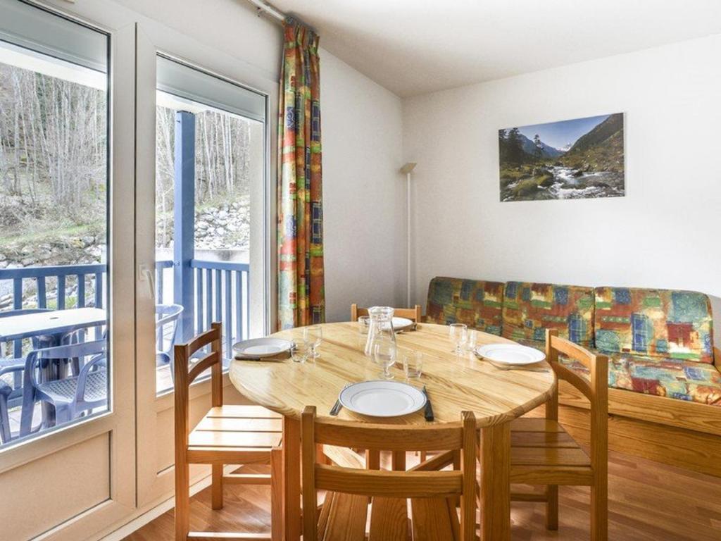 une salle à manger avec une table et des chaises et une fenêtre dans l'établissement Appartement cosy à Cauterets, 4 pers, balcon, proche centre et télécabine - FR-1-401-111, à Cauterets