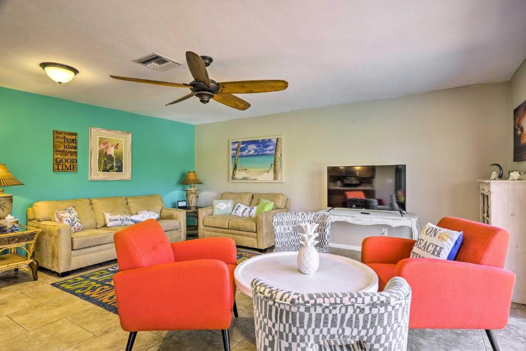 sala de estar con sillas de color naranja y ventilador de techo en Pet-Friendly Fort Myers Home with Heated Pool!, en North Fort Myers