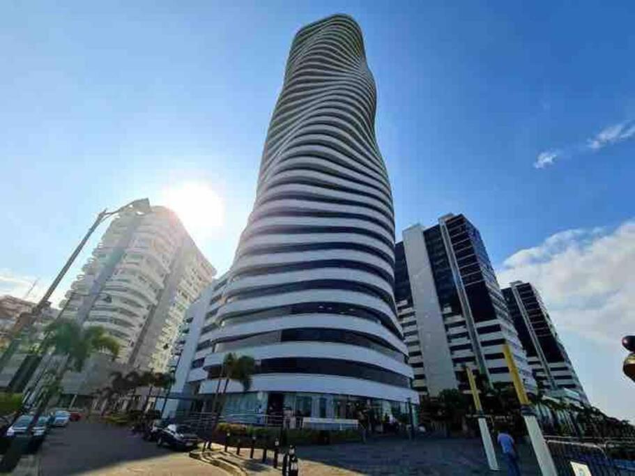 a tall building in front of some tall buildings at Bellini luxury - Puerto Santa Ana in Guayaquil