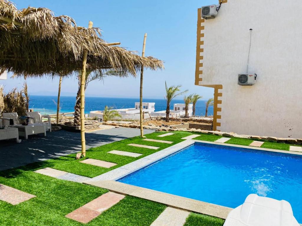 a swimming pool with a view of the ocean at Dahab Hills Villa and Studios in Dahab