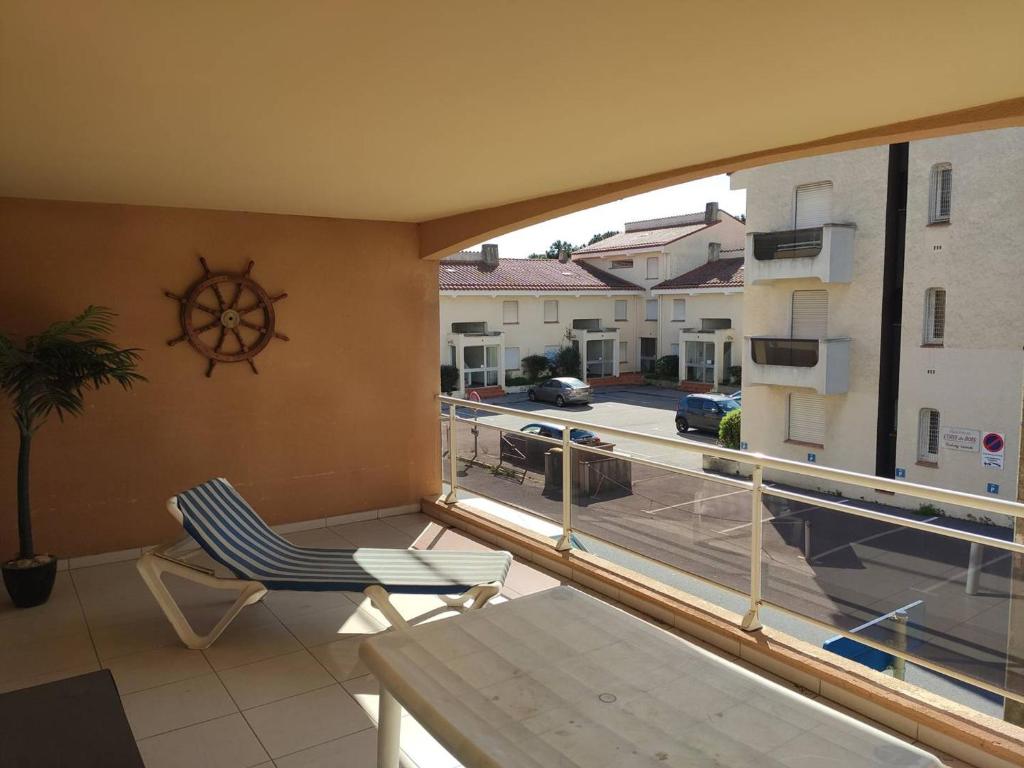 un balcon avec une chaise et une vue sur une rue dans l'établissement Appartement T2 Climatisé, Terrasse de 23m², Piscine, Parking, à 100m de la Plage, Argelès-sur-Mer - FR-1-388-203, à Argelès-sur-Mer