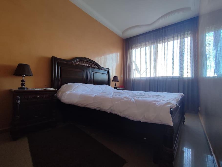 a bedroom with a large bed and two windows at appartement centre in Casablanca
