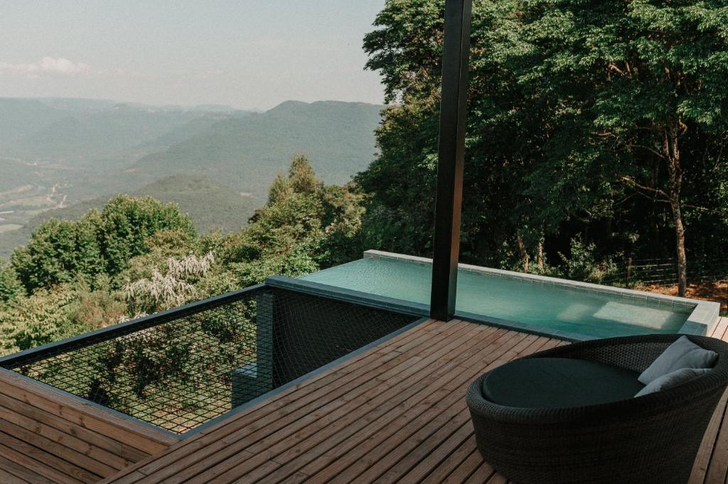 uma varanda com uma piscina de mergulho e uma cadeira num deque em Casas na montanha - Villa Montegrappa em Caxias do Sul