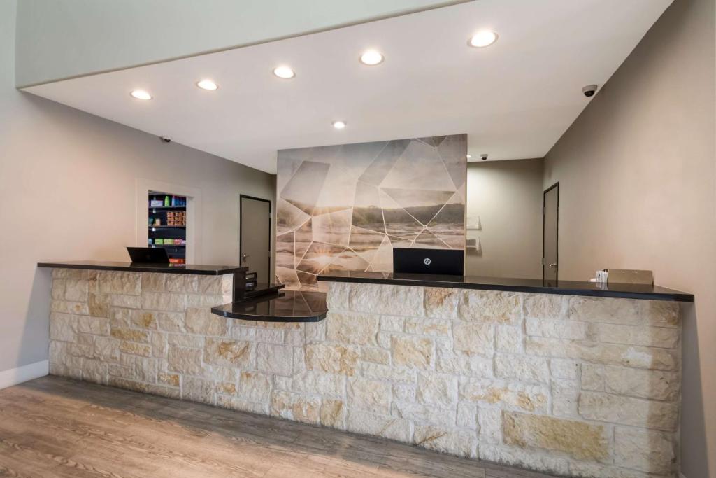 a lobby with a stone counter with a laptop on it at Best Western Plus Killeen - Fort Cavazos Hotel & Suites in Killeen