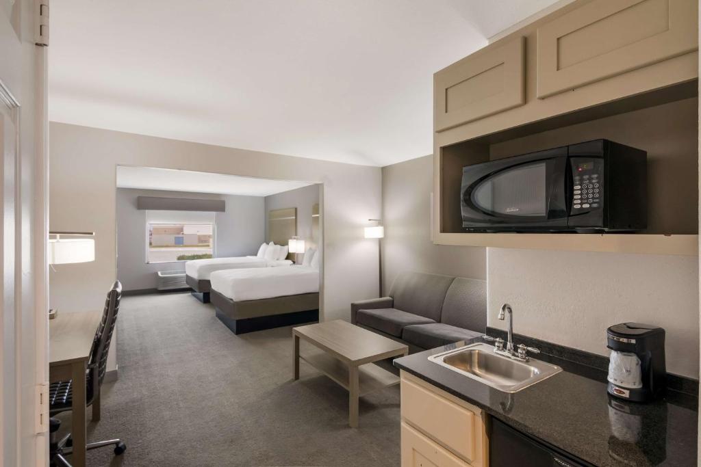 a hotel room with a kitchen and a bedroom at Best Western Plus Killeen - Fort Cavazos Hotel & Suites in Killeen