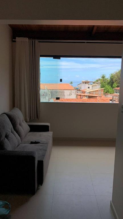 un soggiorno con divano e una grande finestra di Encanto da Vila a Morro de São Paulo