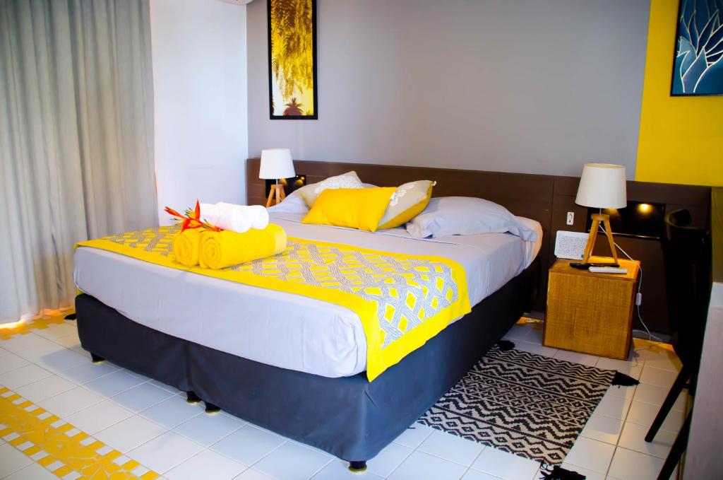 - une chambre avec un grand lit et des oreillers jaunes dans l'établissement Studio Karukera Love, à Saint-François