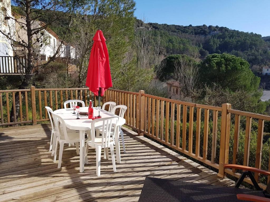 - une table et des chaises sur une terrasse en bois avec un parasol dans l'établissement Maison Duplex 8 Pers avec Terrasse, 3 Ch, Parking Gratuit, Animaux Admis, Accès Piscine - FR-1-382-128, à Grospierres