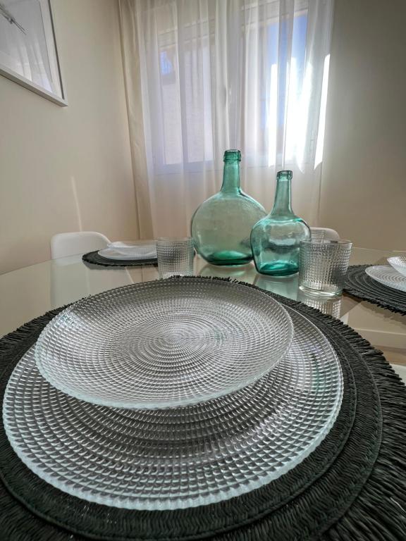 une table avec deux vases en verre et une plaque sur celle-ci dans l'établissement Apartamento Córboba Centro, à Cordoue