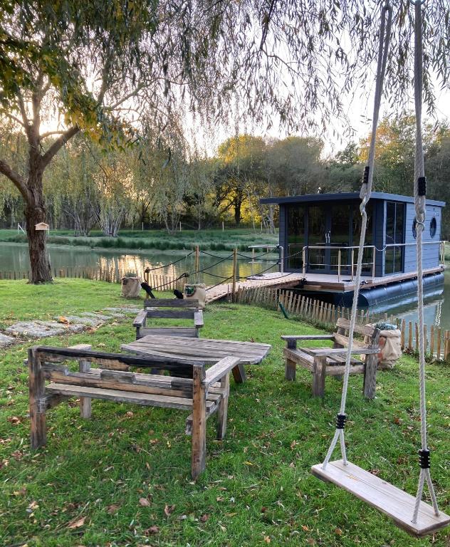 un groupe de tables de pique-nique et de balançoires dans un parc dans l'établissement Ecolodge Charles Ashton Hébergement insolite sur l'eau, à Sarzeau