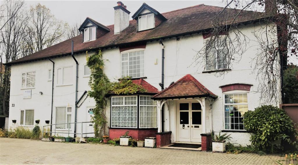 una casa blanca con un rojo en Lyttleton Lodge, en Uxbridge